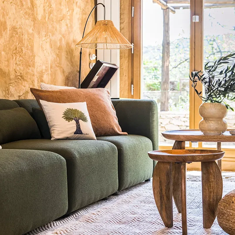 Proyecto de interiorismo en la Sierra de Aracena, salón con sofá verde y elementos naturales
