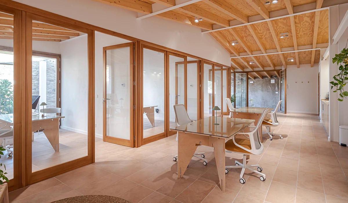 Interior de las oficinas de Almanatura en Arroyomolinos de León con zona de trabajo compartida y estructura de madera